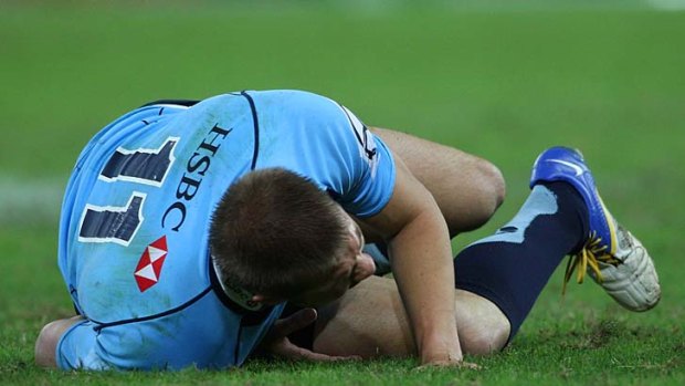 Pass the morphine ... Drew Mitchell writhes in agony after dislocating his ankle on Saturday night.