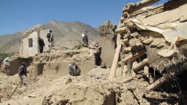 Afghan villagers search for bodies of persons killed in a NATO airstrike.