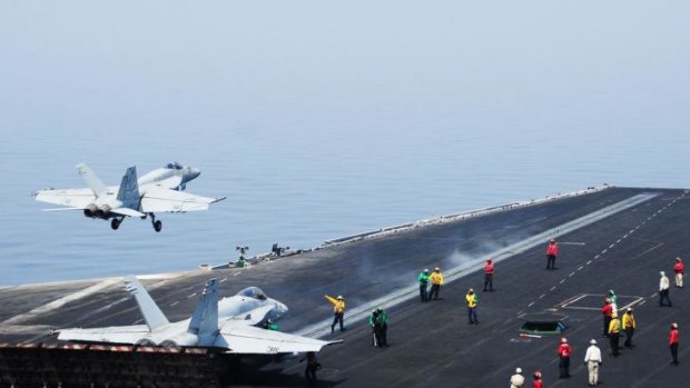 Patrolling Iraqi skies ... Sailors direct an aircraft, as an F/A-18E Super Hornet takes off from the flight deck of the aircraft carrier USS George H.W. Bush. 
