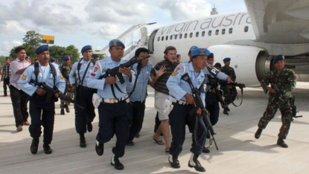 Matt Lockley (centre back) is arrested by Indonesian Air Force soldiers after landing on the Virgin Australia 737-800 plane at Ngurah Rai airport in Denpasar on the resort island of Bali on April 25, 2014.