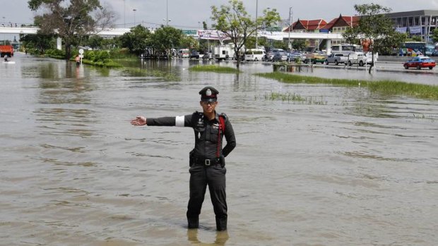 A policeman directs traffic in a flooded area in Ayutthaya province.
