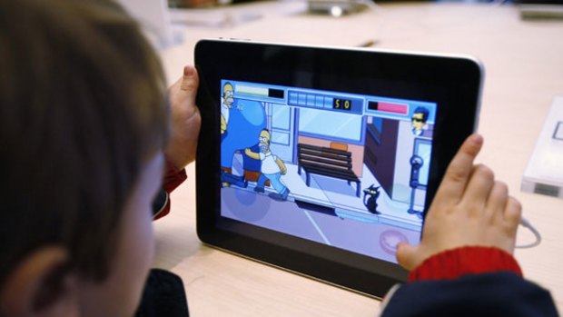 Rowan Hall, 5, plays a game based on the popular animated series "The Simpsons" on an Apple iPad.