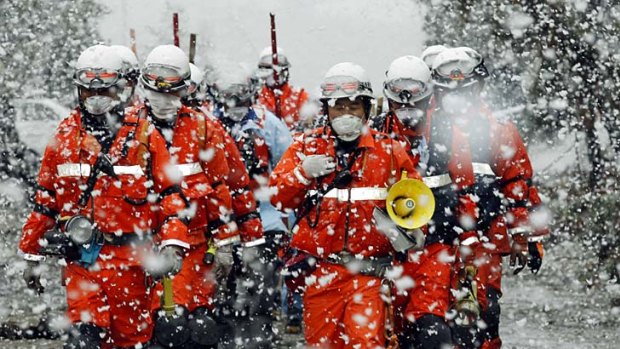Deep freeze  ... rescue workers brave the elements at an industrial area in Sendai that was devastated by the earthquake and tsunami.