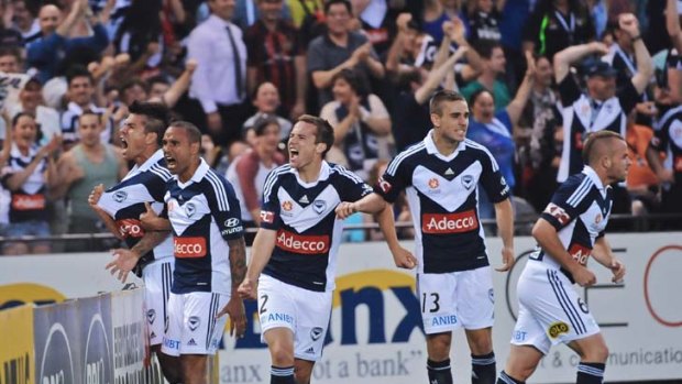 And the crowd goes wild: Archie Thompson celebrates goal number one with his team mates.