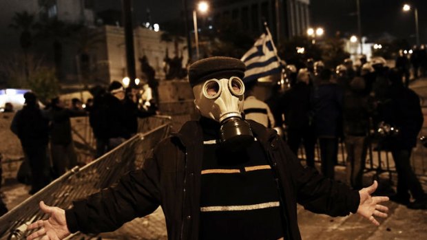 A Greek protester in a gas mask poses during clashes with riot police in front of the Greek parliament in Athens. Tens of thousands of people massed for the rally.