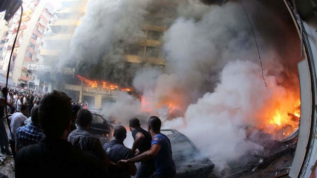 Lebanese fire fighters extinguish a flame at the site of a car bomb between the Bir el-Abed and Roueiss neighbourhoods, in the southern suburb of Beirut.