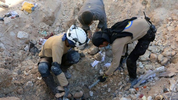 Members of Civil Defence removing a dead body from under the rubble after airstrikes hit in Aleppo.