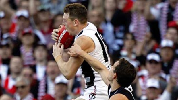 St Kilda's Brendon Goddard climbs over Magpie opponents to take the mark of the day late in Saturday's grand final.
