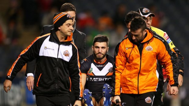 Bitter blow: Wests Tigers fullback James Tedesco is stretchered off Campbelltown Stadium after injuring his knee against Canberra.