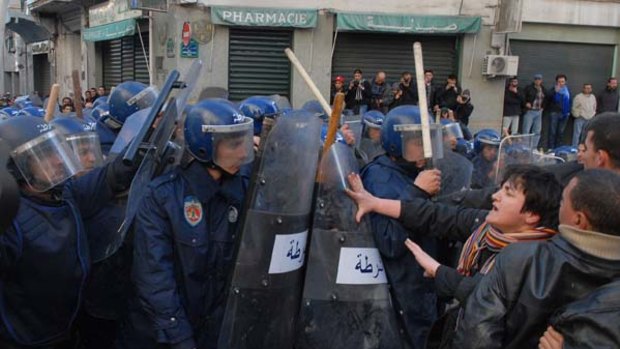 Ring of steel ... protestors jostle against a wall of policemen, armed with batons and tear gas, during a demonstration in Algiers on January 22.