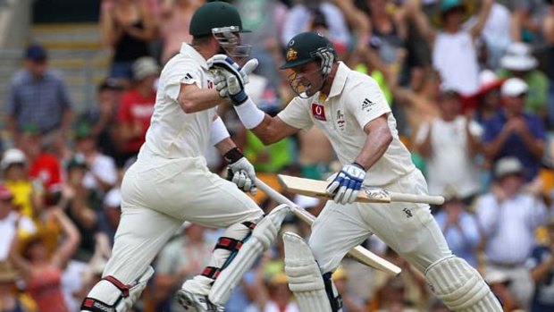 Australian duo Brad Haddin (left) and Michael Hussey cross over on their way towards building a big lead for Australia at the Gabba.