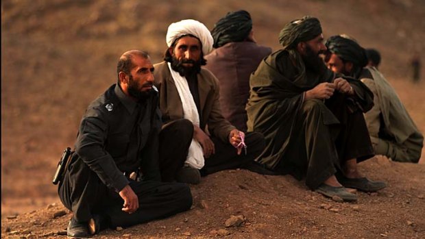 Power to his people: Matiullah Khan (left) talks to men in the Tarin Kowt district.