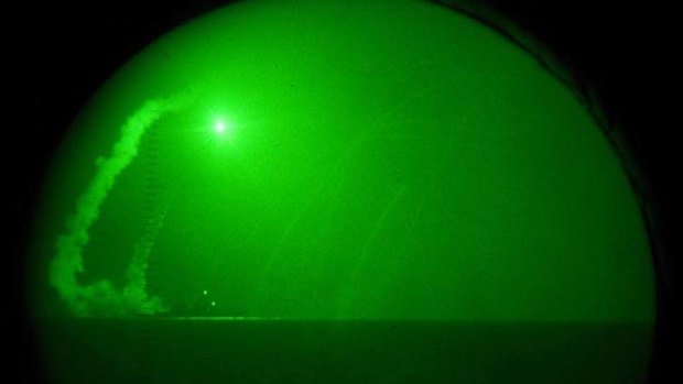 Seen through night-vision lenses, guided missile destroyer USS Barry fires Tomahawk cruise missiles in the Mediterranean Sea.