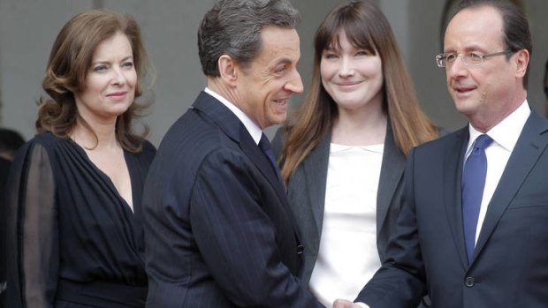 Valerie Trierweiler looks on as French President, Francois Hollande, right, shakes hands with Nicolas Sarkozy.