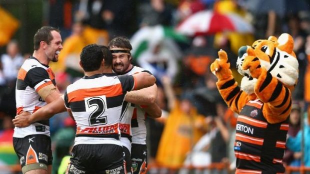 Front-rower Aaron Woods celebrates with teammates and the mascot after scoring in the Wests Tigers' big win over Manly at Leichhardt.