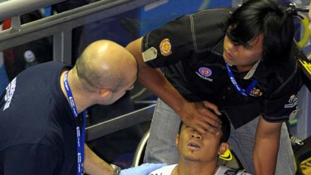 Azizulhasni Awang of Malaysia is treated by a medic after crashing and suffering a leg wound in the men's keirin Final at the UCI World Cup. He pushed his bike across the line to finish third.