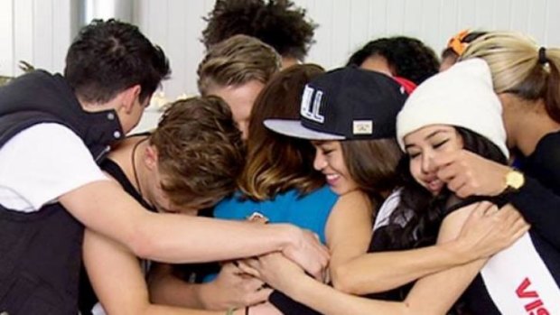 Now wielding 'wildcards' ... Dannii Minogie (centre blue) hugs it out with her team.