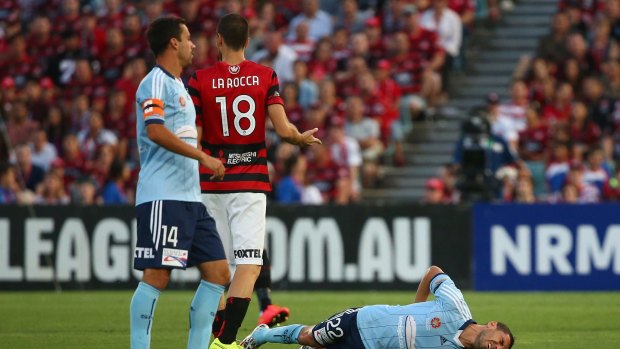 Ouch: Sydney FC star Ali Abbas lies prone after suffering a season-ending injury in the tackle of Western Sydney Wanderers' Iacopo la Rocca.