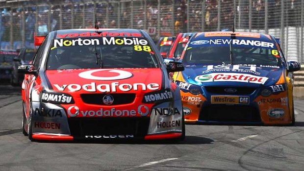 Jamie Whincup of the #88 Team Vodafone Holden holds the lead from Will Davidson of the #6 Trading Post Ford Team.