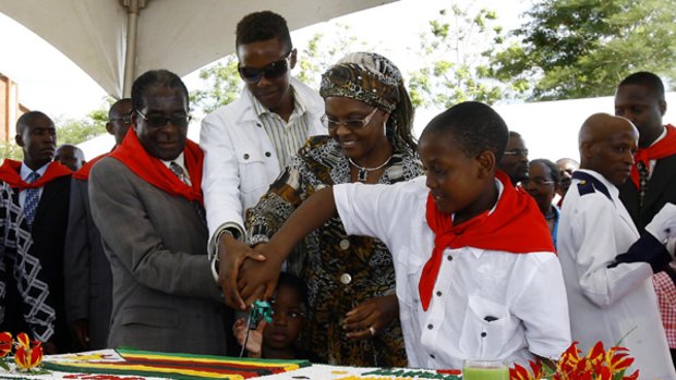 Having his cake...from left, Robert Mugabe, his son Robert jnr, his wife Grace and his youngest son Chatunga at the birthday celebration.