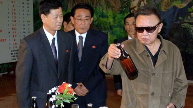 Checking the credentials ... Kim Jong-il examines a bottle during a visit to a chemistry company in North Korea.