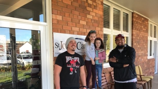 Sylvie Redwin, five, and her older sister Ariella, eight, at St John's Care Reid where Sylvie handed over her $500 donation to YouthCare Canberra outreach workers Zack Bryers and Richie Unga.