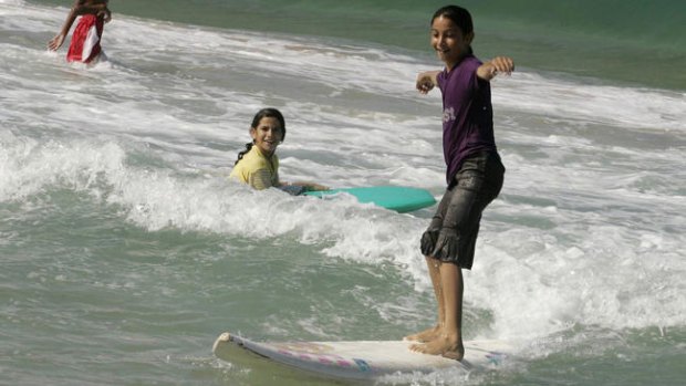 Palestinian girl Sabah Abu Ghanim catches a wave in the Mediterranean off the coast of Gaza.