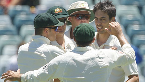Teammates rush in to congratulate Australian fast bowler Mitchell Johnson for taking the wicket of Deonarine.