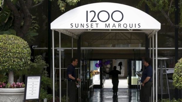A man carries flowers into the Sunset Marquis hotel where U2 tour manager Dennis Sheehan was pronounced dead in his hotel room, according to local media, in West Hollywood.