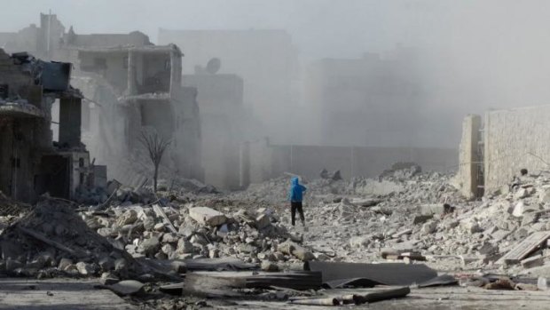 War rages unchecked: A Syrian man walks amid debris and dust following an air strike on Friday, allegedly by government forces.