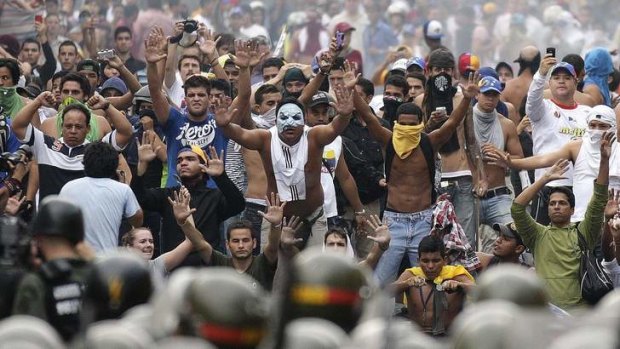 Supporters of opposition leader Henrique Capriles face off against riot police in Caracas.