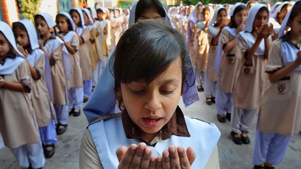 Living in hope ... Pakistani schoolgirls pray for peace campaigner Malala Yousafzai.