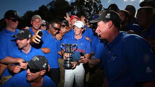 Luck of the Irish: Rory McIlroy shares his elation with greenkeeping staff after beating Adam Scott by one shot.