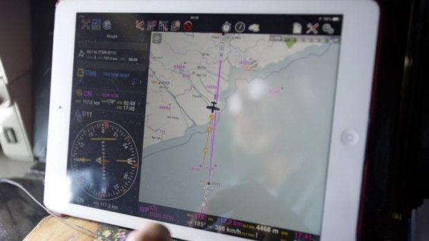 The search continues ... Military officer Ngo Ngoc Dong is seen reflected in a map on an iPad showing the path of the Vietnam Air Force search and rescue AN-26 aircraft.