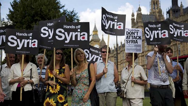 People take part in a protest calling for no military attack on Syria outside the Houses of Parliament in London.