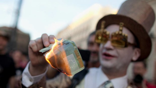 Burning cash: A costumed Spaniard displays his anger.