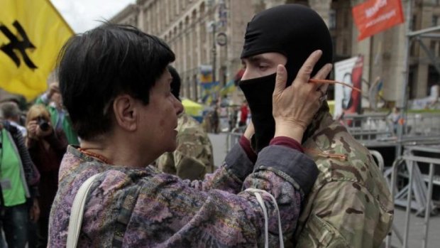 A woman speaks with a volunteer during a rally in Independence Square in Kiev on Sunday before the man set off for eastern Ukraine to join the ranks of the pro-government 'Azov' battalion.