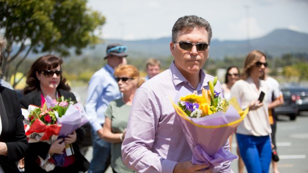 Dreamworld chief executive Craig Davidson leaves flowers at the site on Friday after a private memorial service at Dreamworld.