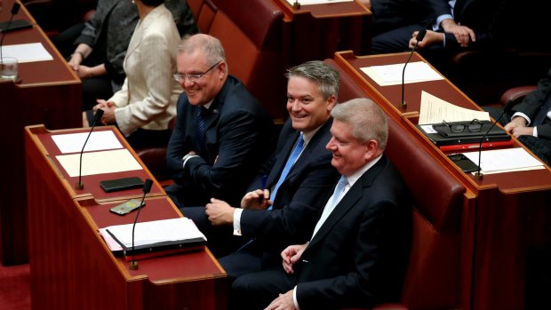 NBN Shareholder ministers Senator Mathias Corman (centre) and Senator Mitch Fifield (right), sitting with Treasurer Scott Morrison at the opening of Parliament in April. 