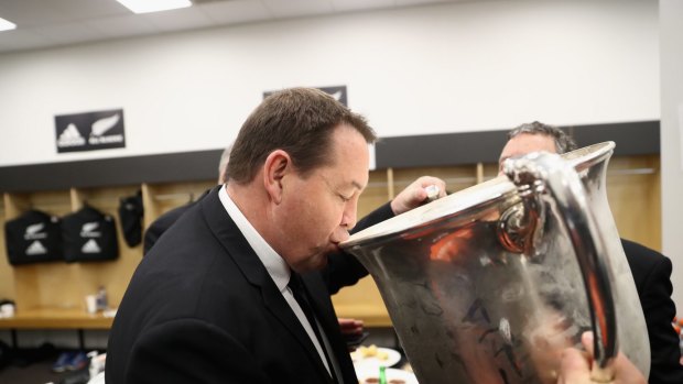 Winners are grinners: All Black coach Steve Hansen drinks from the Bledisloe Cup.