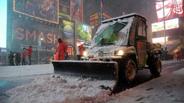 Workers shovel snow in Times Square in New York.