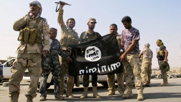Pro-government Iraqi forces deface the flag of Islamic State after recapturing the northern town of Amerli on September 1.