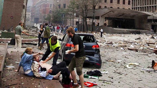 An injured man is attended to at the site of a powerful explosion that rocked central Oslo.