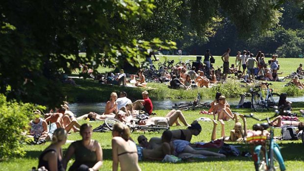 Mostly clothed people relax in Munich's English Garten park. The naked sunbathers who once crowded Germany's Baltic beaches and city parks are becoming an endangered species.
