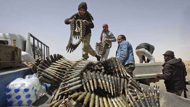 Libyan rebel fighters load a truck with ammunition on the outskirts of Ajdabiya.