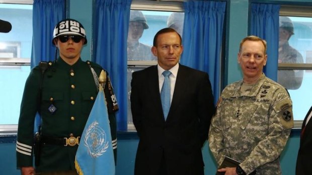 North Korean soldiers stare at Prime Minister Tony Abbott through the window as he tours the T2 hut at the Korean Demilitarized Zone (DMZ) during his visit to the Republic of Korea on Wednesday.