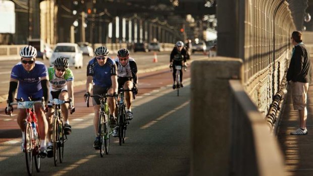 Cyclists ride over the Sydney Harbour Bridge.