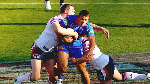 Lisiate Richie Fa'aoso of the Knights is tackled by Jason Ryles of the Roosters.