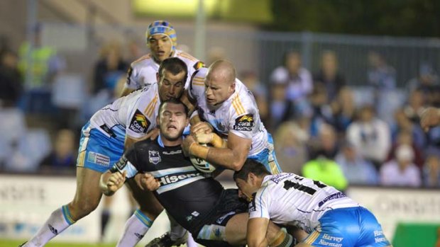Paul Gallen is tackled by Titans players.