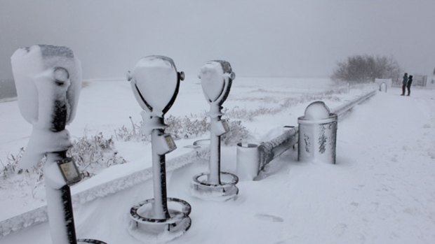 Telescope viewers are covered in snow overlooking Lighthouse Beach Sunday in Chatham, Massachusetts.